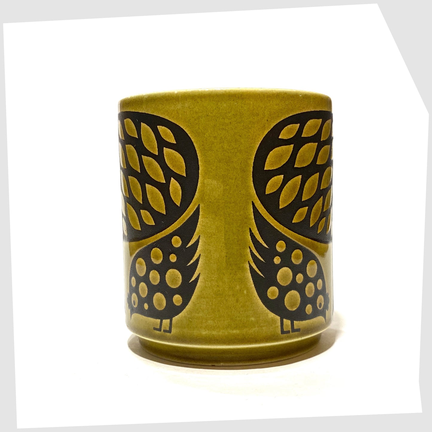 Vintage Hornsea Pottery Mug featuring a pair of partridge birds at the base of a tree, in an olive green glaze with lack decals, shown on a white background