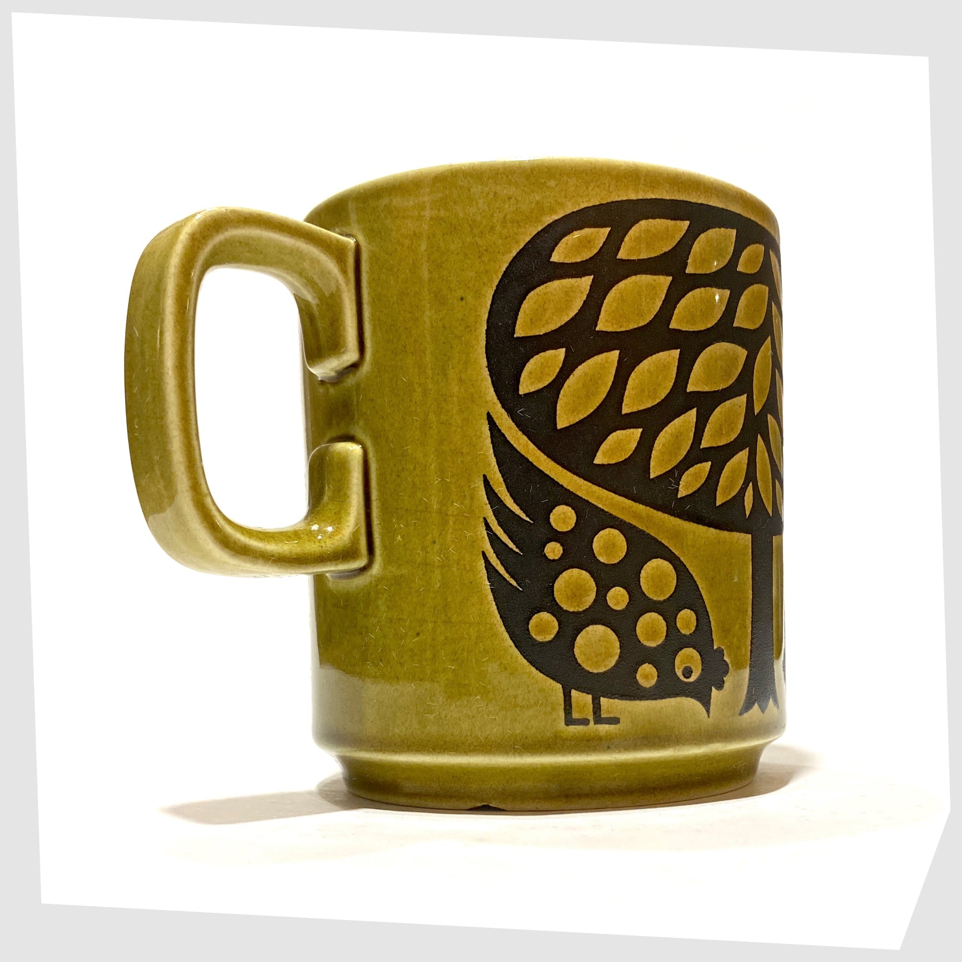 Original 1970s Hornsea Pottery Mug featuring a pair of partridge birds at the base of a tree, in an olive green glaze with lack decals, shown on a white background