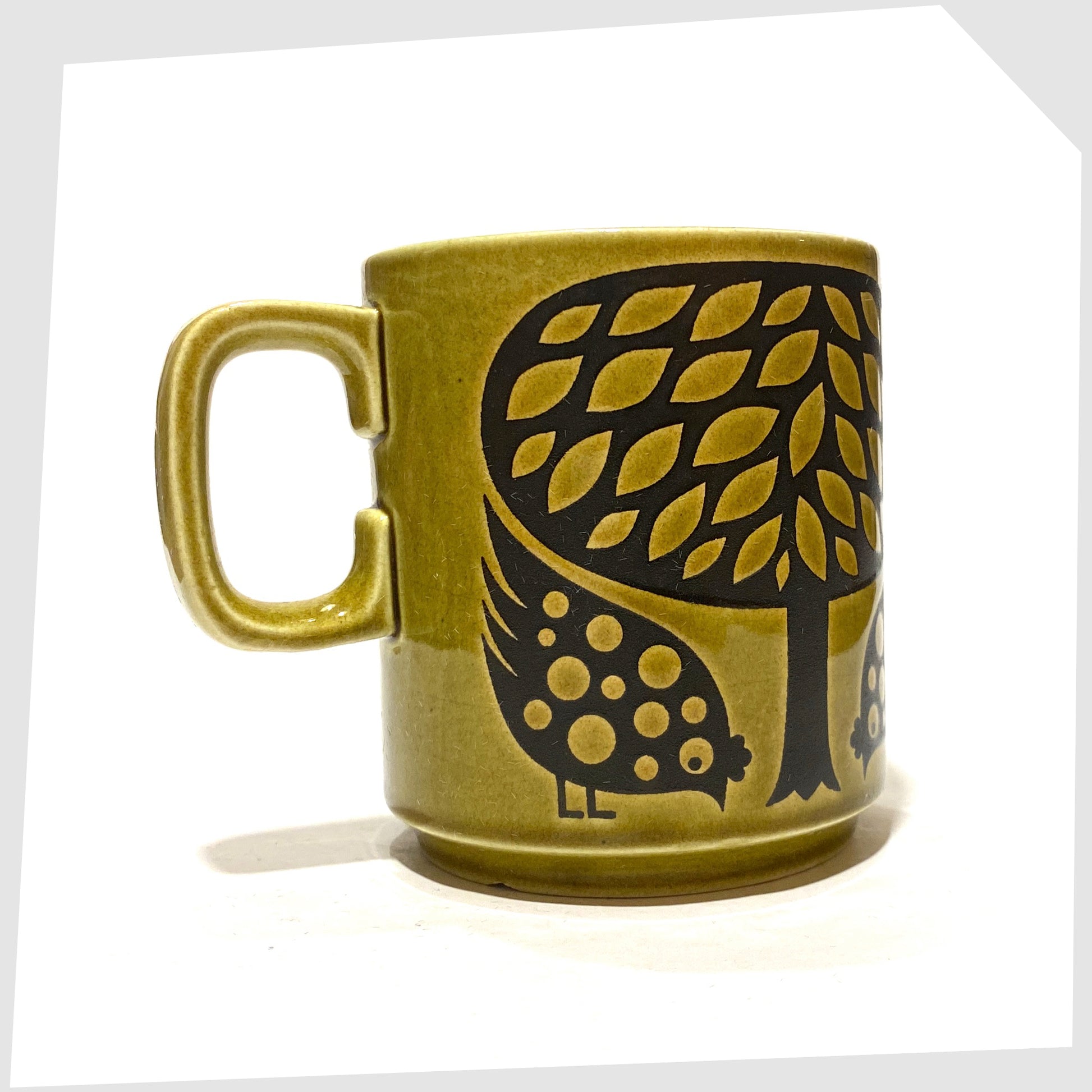 Original 1970s Hornsea Pottery Mug featuring a pair of partridge birds at the base of a tree, in an olive green glaze with lack decals, shown on a white background