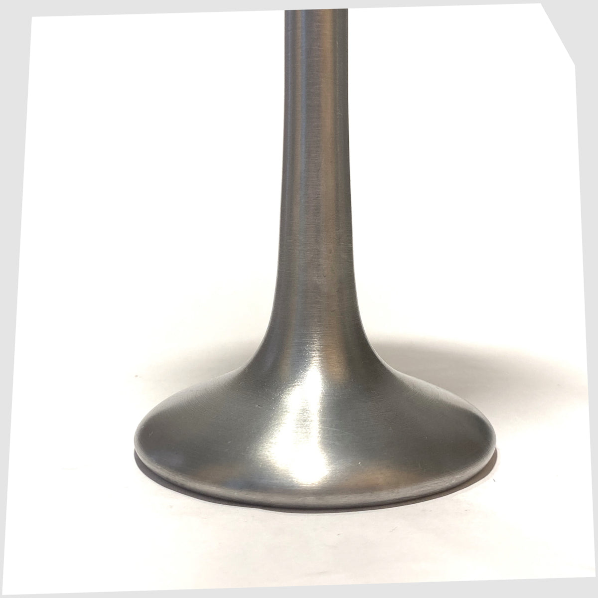 Base of the Ikea Kagla Candleholder made of brushed aluminium, shown on a white background