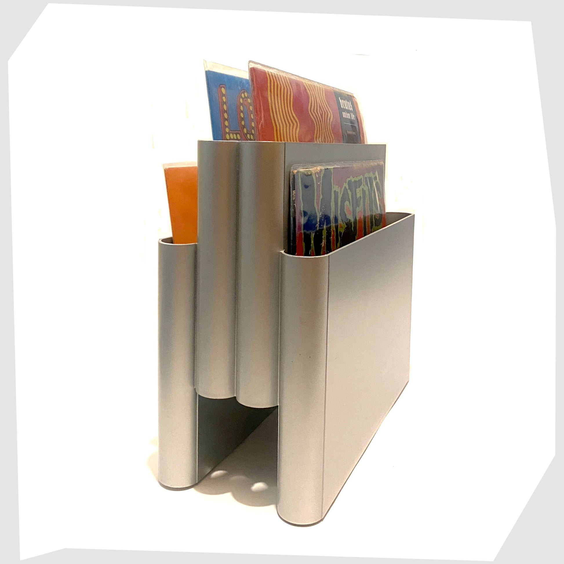 vintage-kartell-magazine-rack-in-silver-colourway-holding-vinyl-records-and-magazines