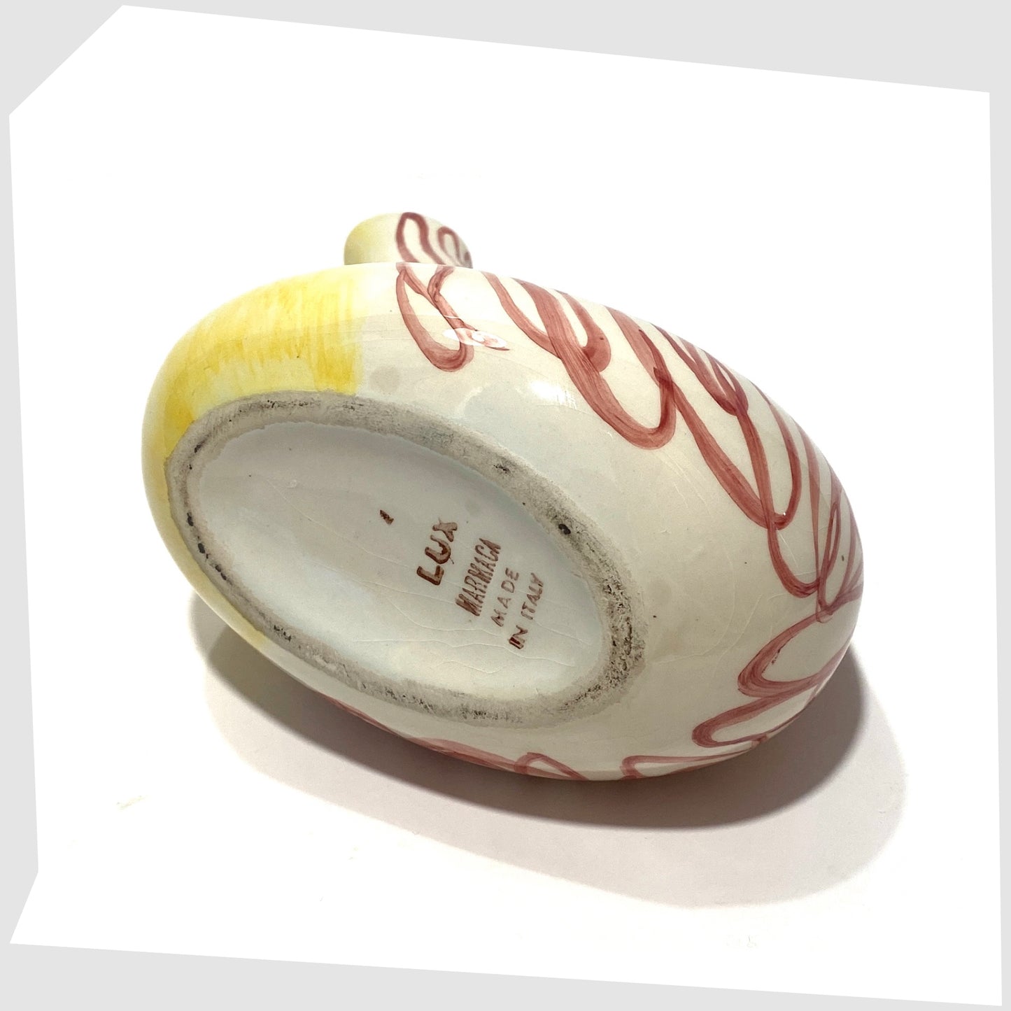 base of the Lux Marmaca Italian Pottery Pitcher in a yellow and white glaze with hand drawn red lines