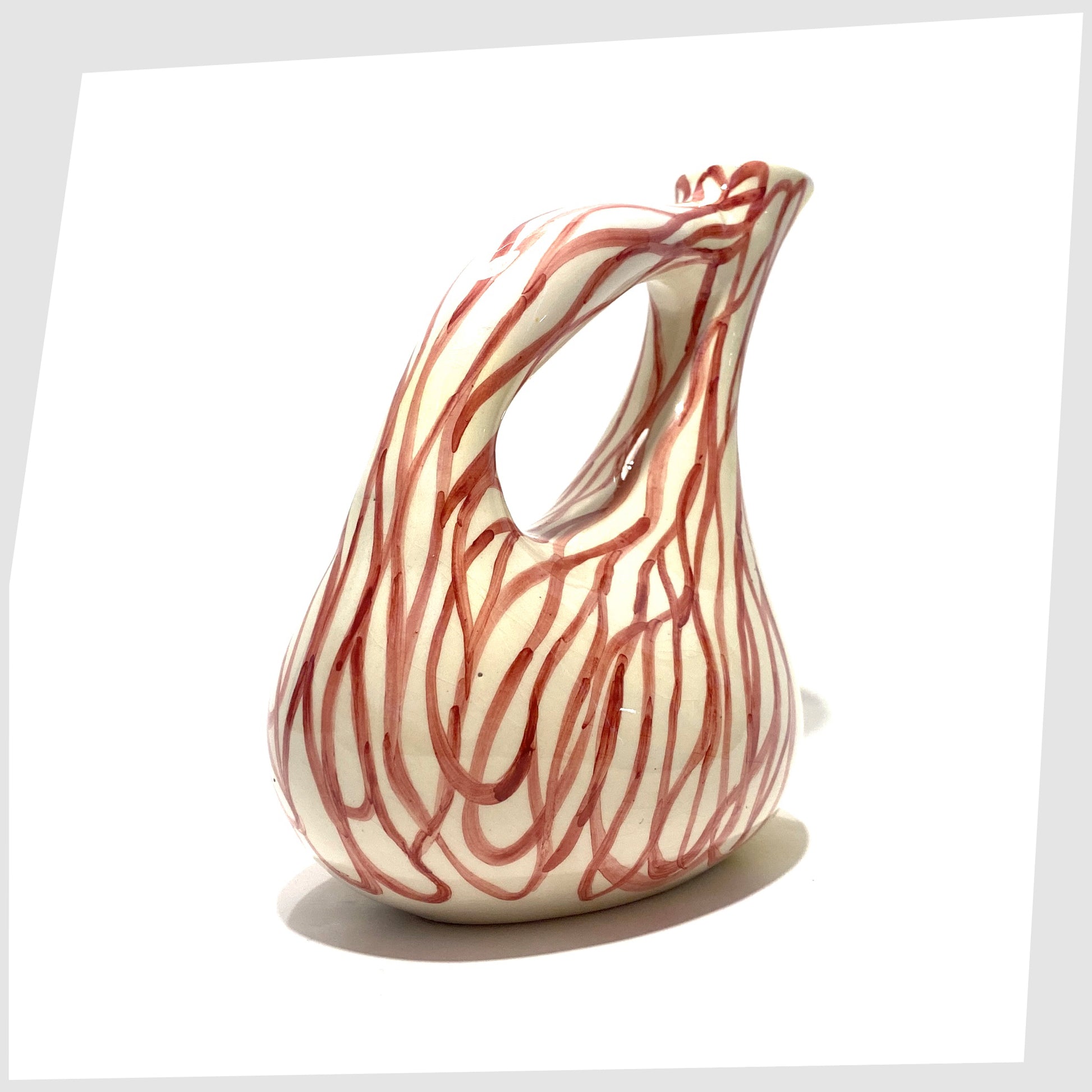 handle of the Lux Marmaca Italian Pottery Pitcher in a yellow and white glaze with hand drawn red lines