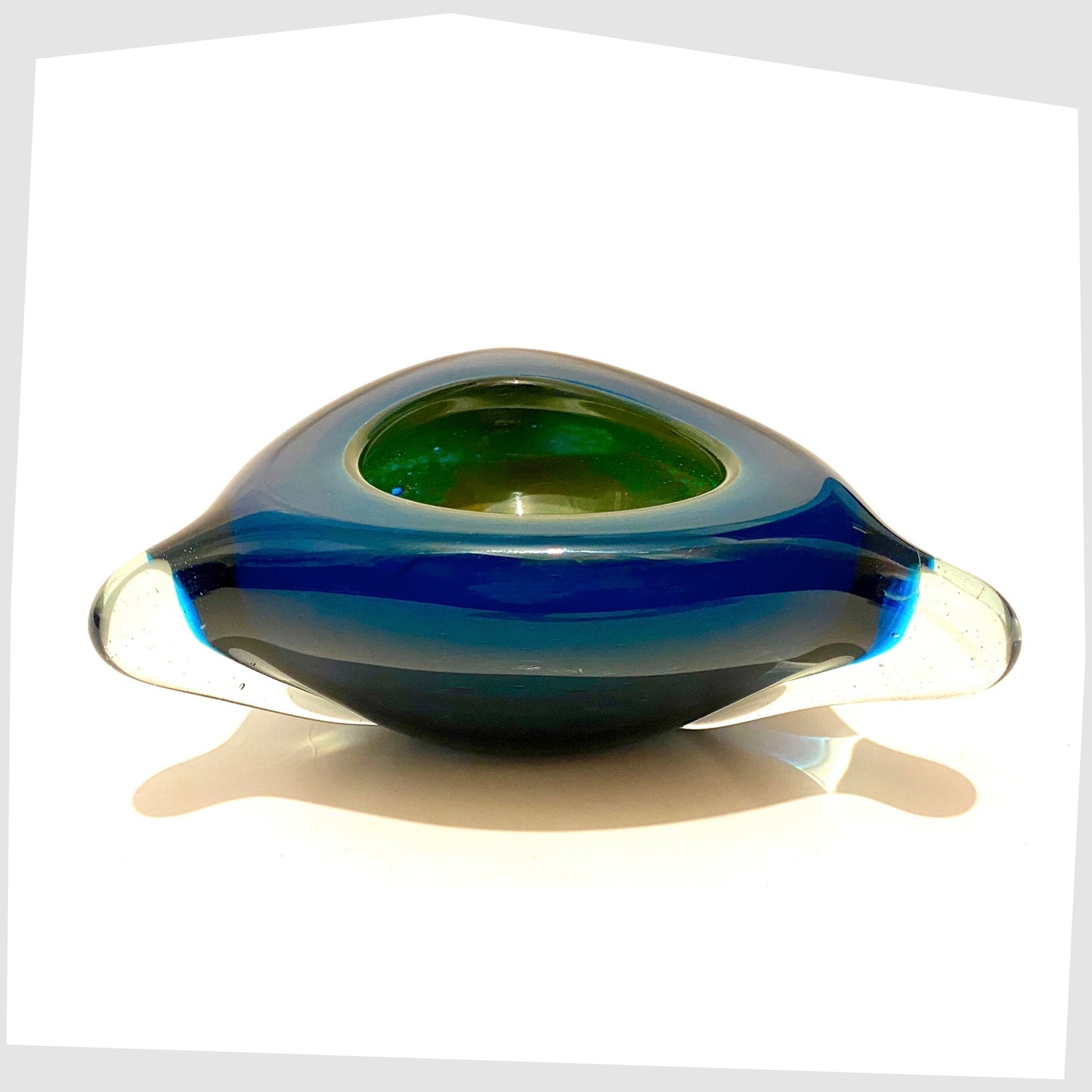 mdina glass dish in teal blue cased glass pulled into a triangular shaped bowl