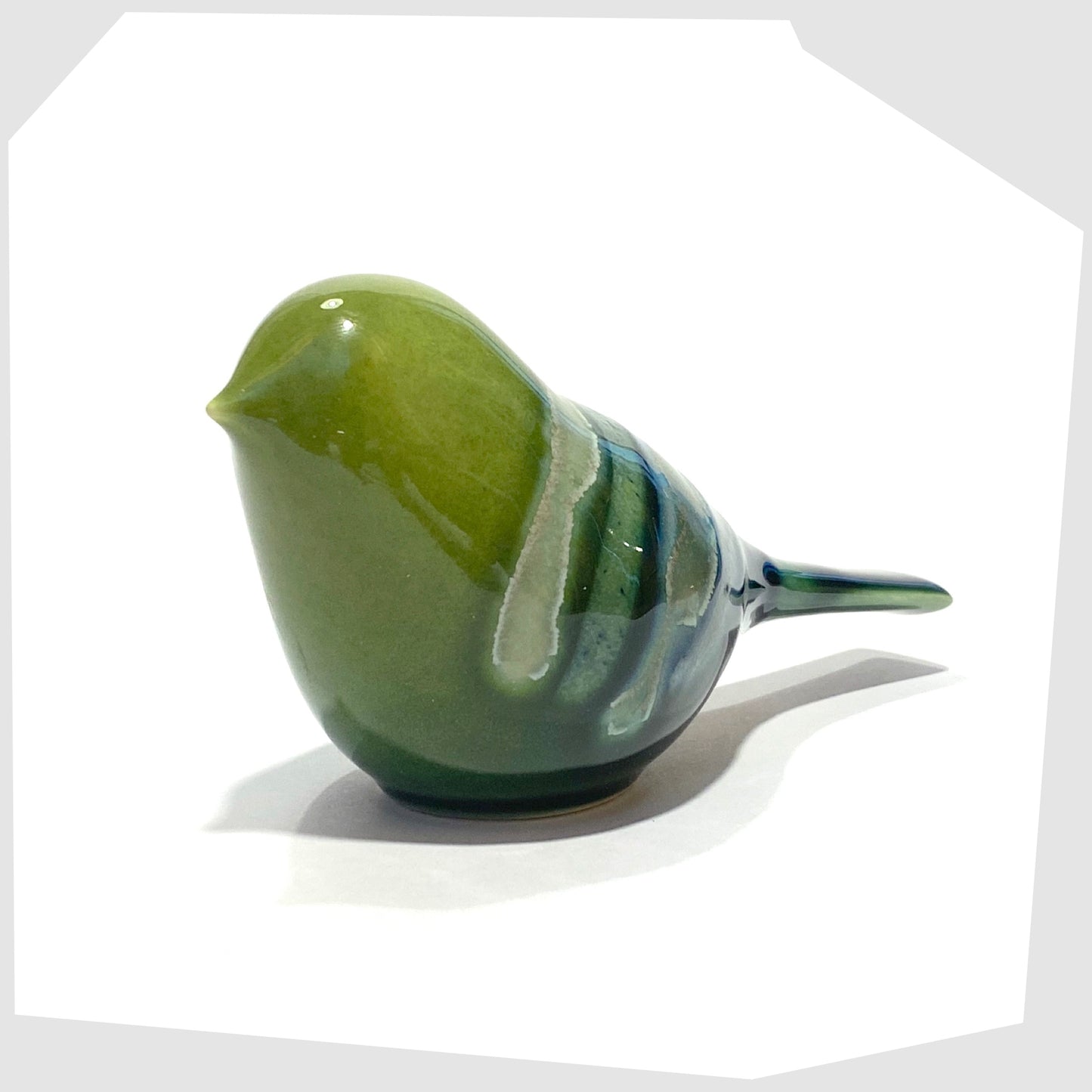 front of the poole pottery perching bird ornament in maya glaze of green, blue and warm grey