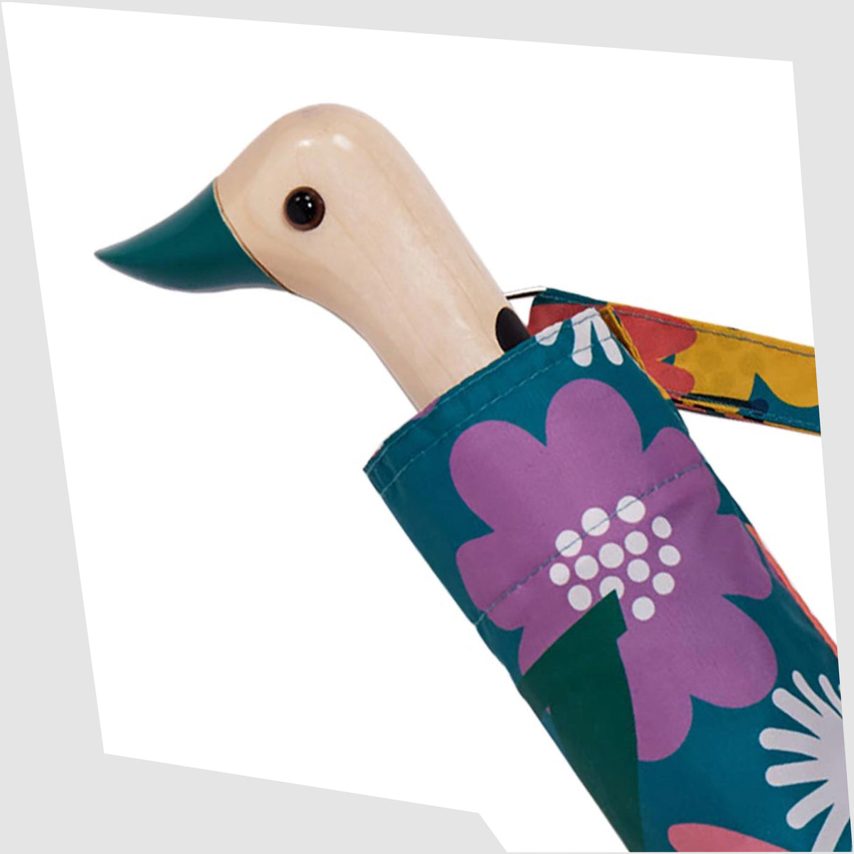 Close up of the birchwood duck-shaped handle of the Original Duckhead Umbrella in Bloom print of multicoloured stylised flowers on a teal fabric, shown on a white background