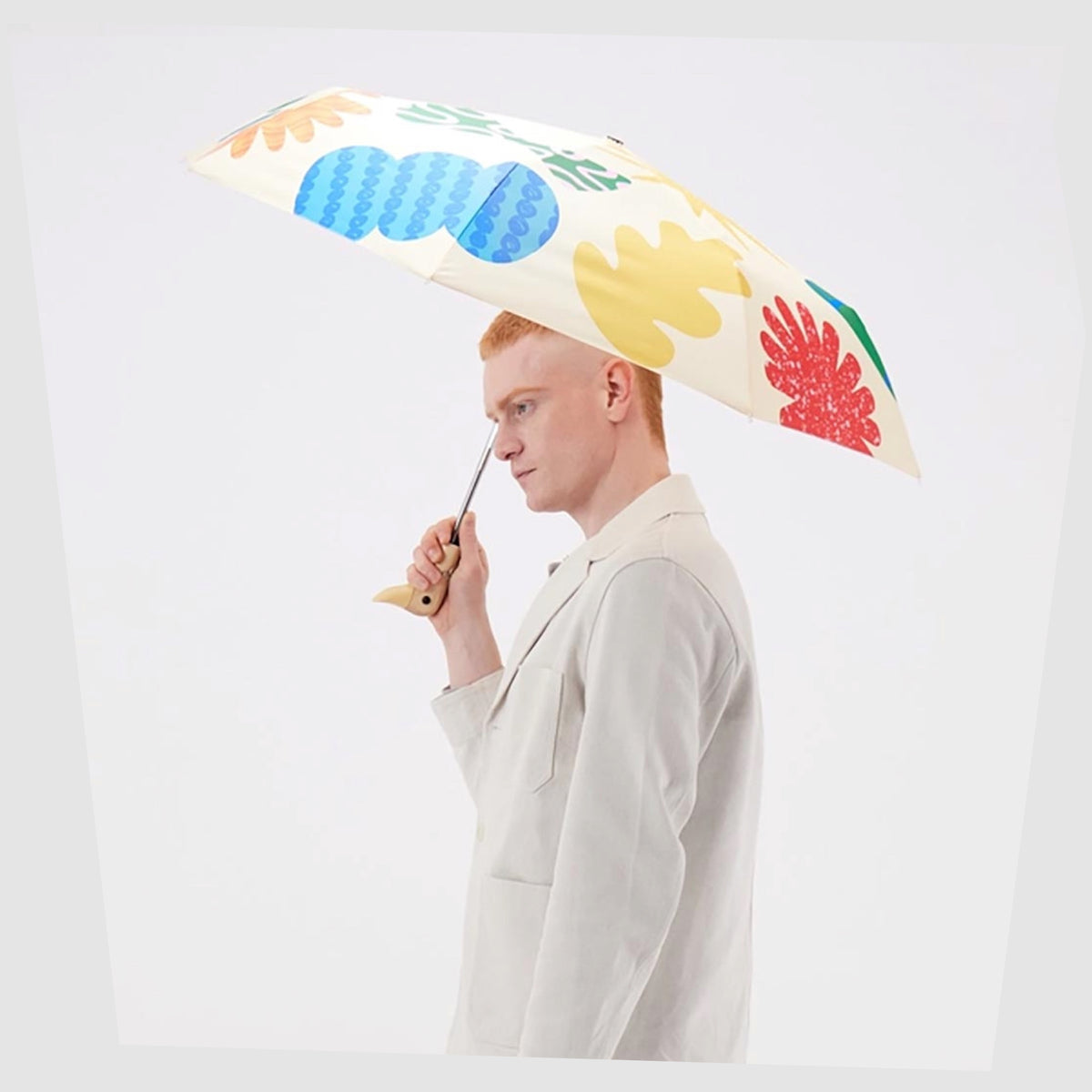 Lifestyle image of the Original Duckhead Umbrella in Deli pattern shown open in a person's hand