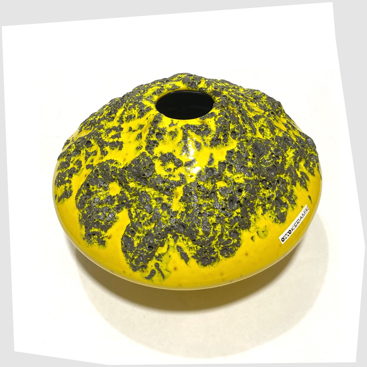Overhead view of the Otto Keramik Vase, model 203, in vibrant yellow glaze with grey fat lava, shown on a white background