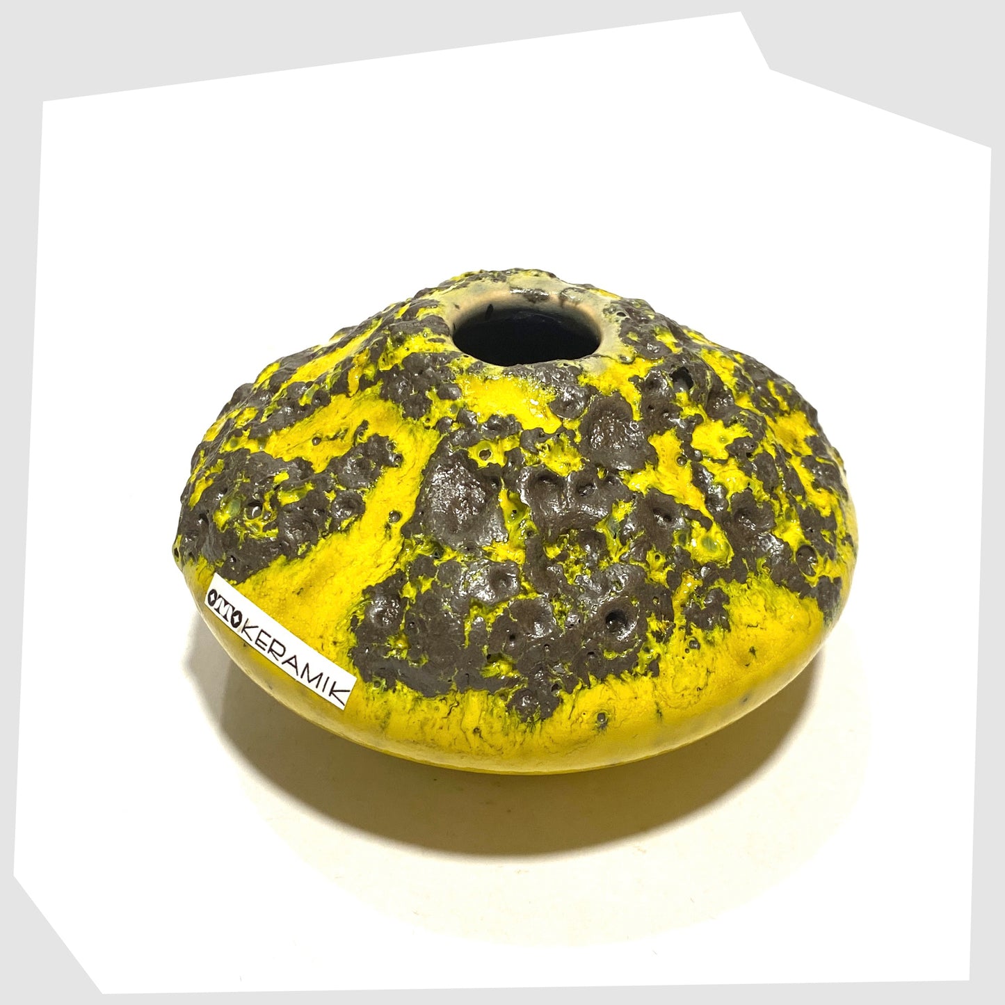 top rim of the Otto Keramik 203 Vase in yellow with grey fat lava glaze, shown with the otto keramik sticker on a white background