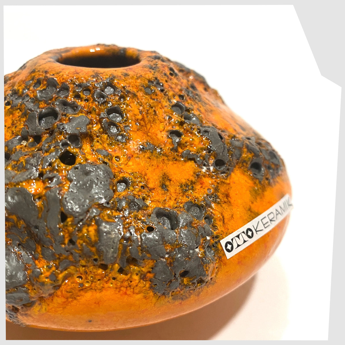 Close up of the Otto Keramik Vase, model 203s, in orange glaze with grey fat lava, shown on a white background