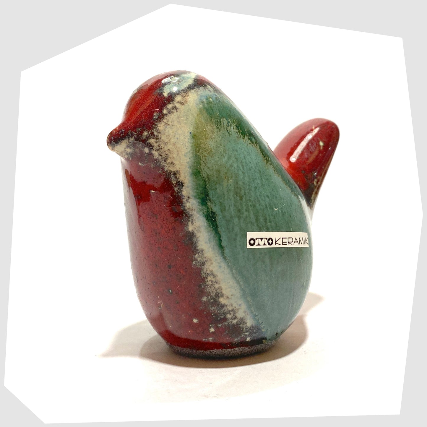 front of the otto keramik ceramic bird figurine in bolivia glaze consisting of rich red and sea green