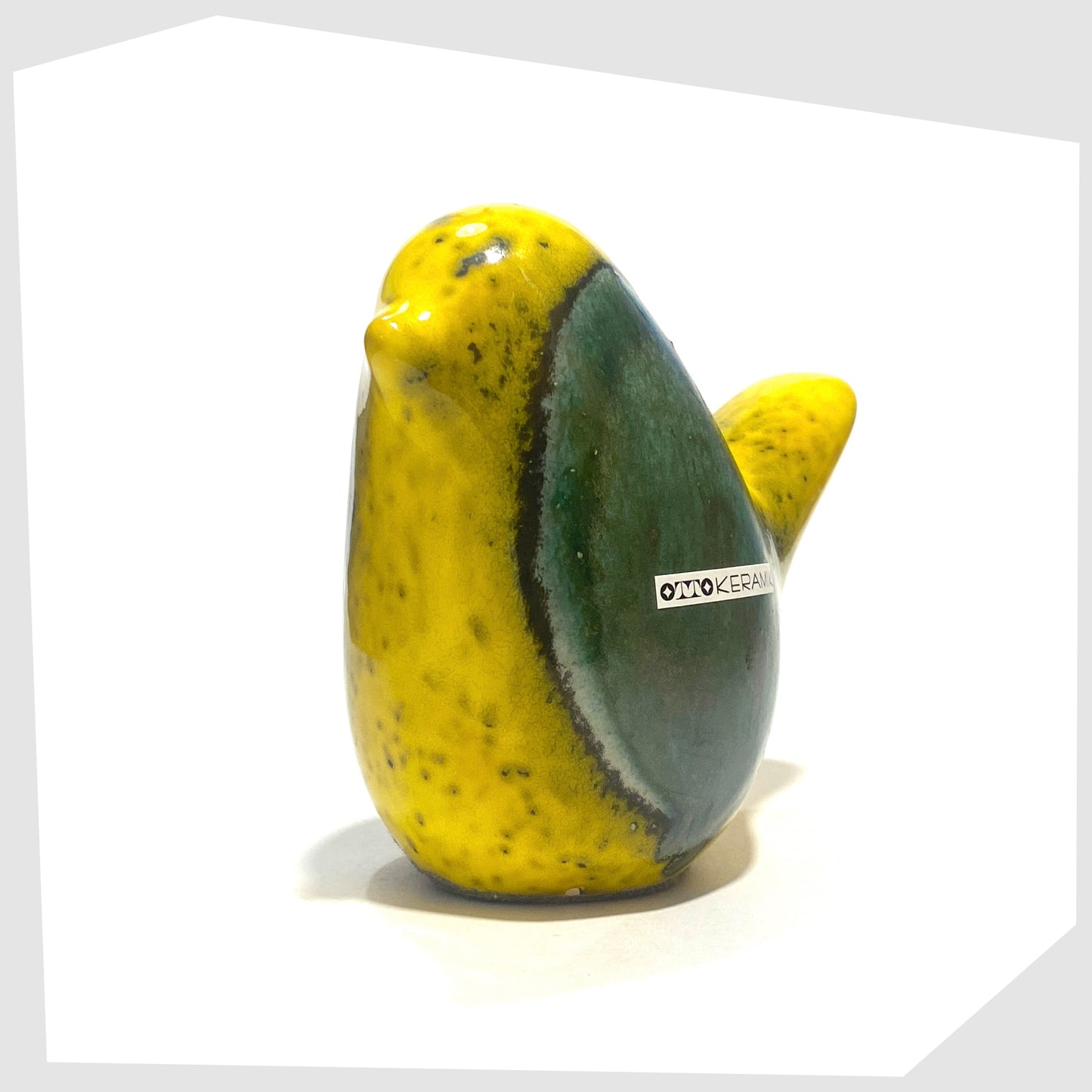 front of the otto keramik ceramic bird ornament in brazil glaze of vibrant yellow and rich sea green