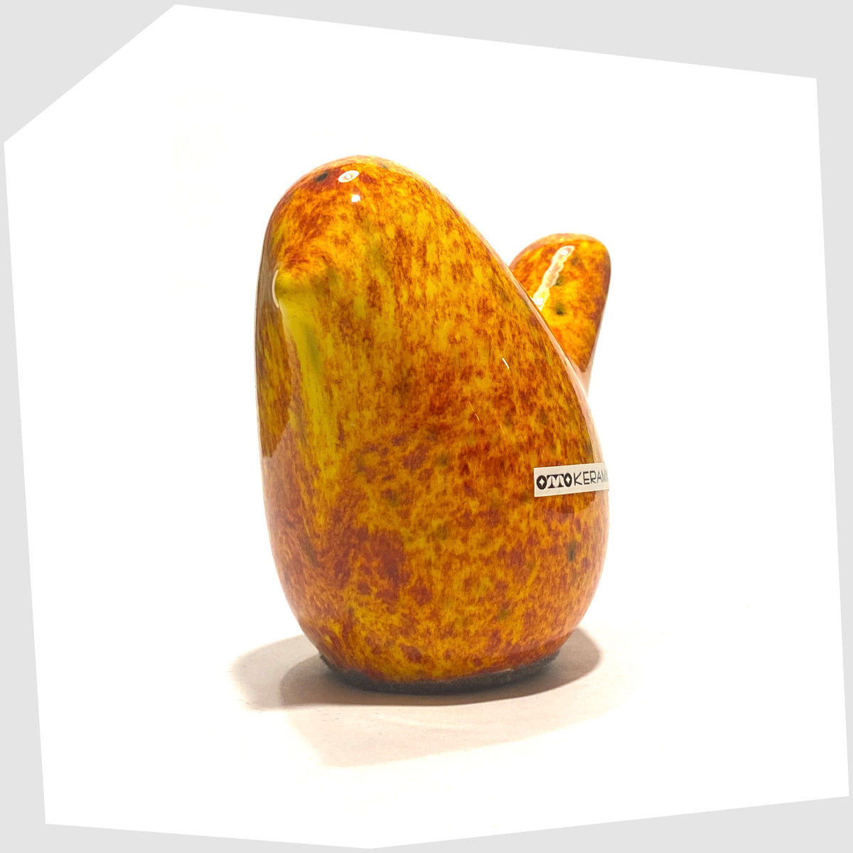 Front of the Otto Keramik Bird in Fire glaze of orange, red and yellow flecks, shown on a white background