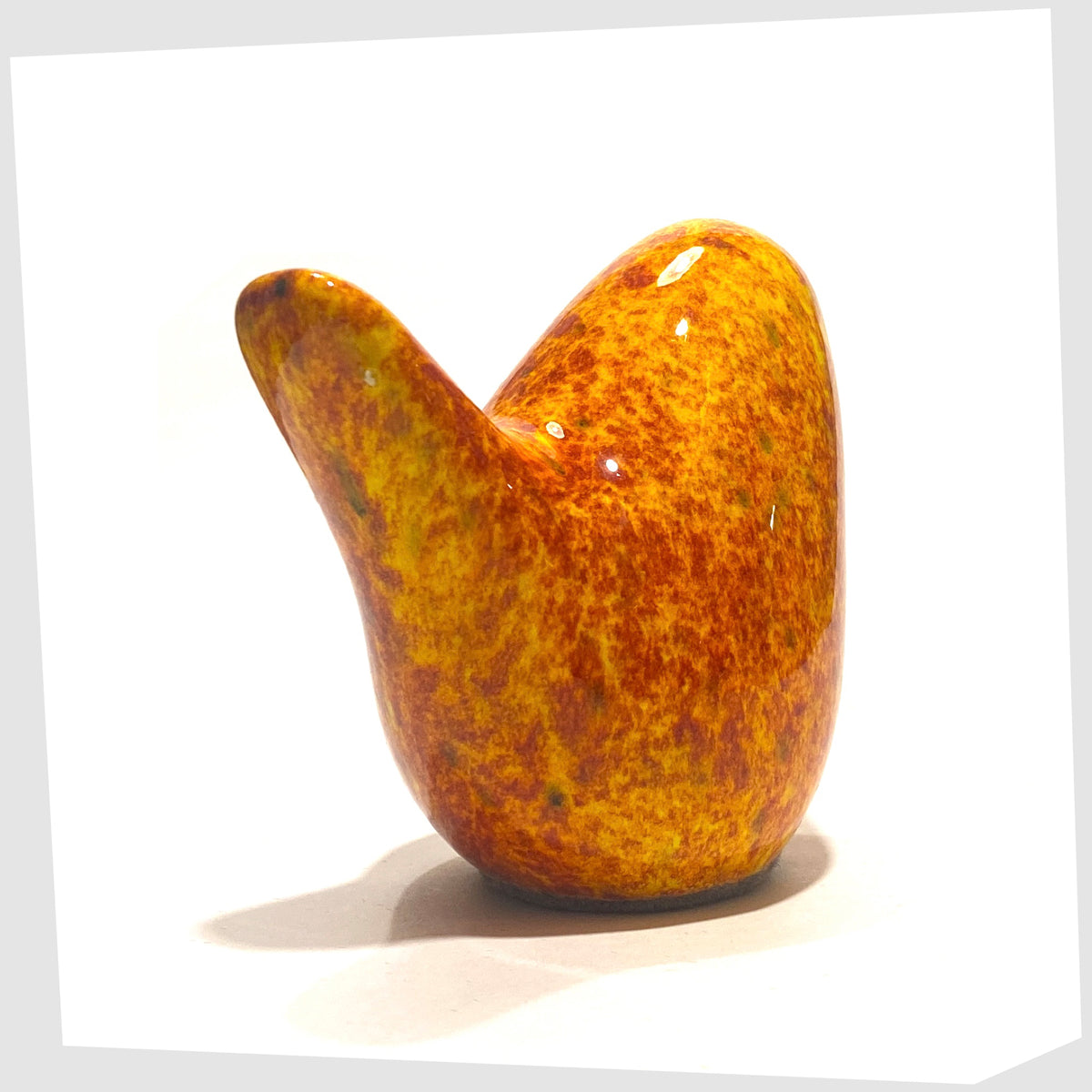 Rear of the Otto Keramik Bird in Fire glaze of orange, red and yellow flecks, shown on a white background