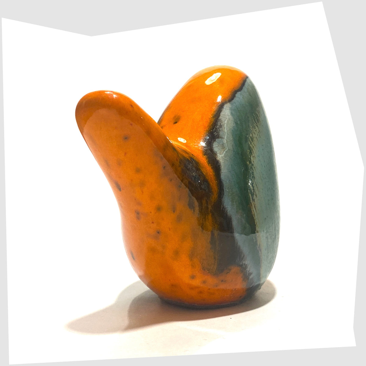 Rear angle of the Otto Keramik Ceramic Bird in Peru glaze of orange with sea green drip glaze, shown on a white background