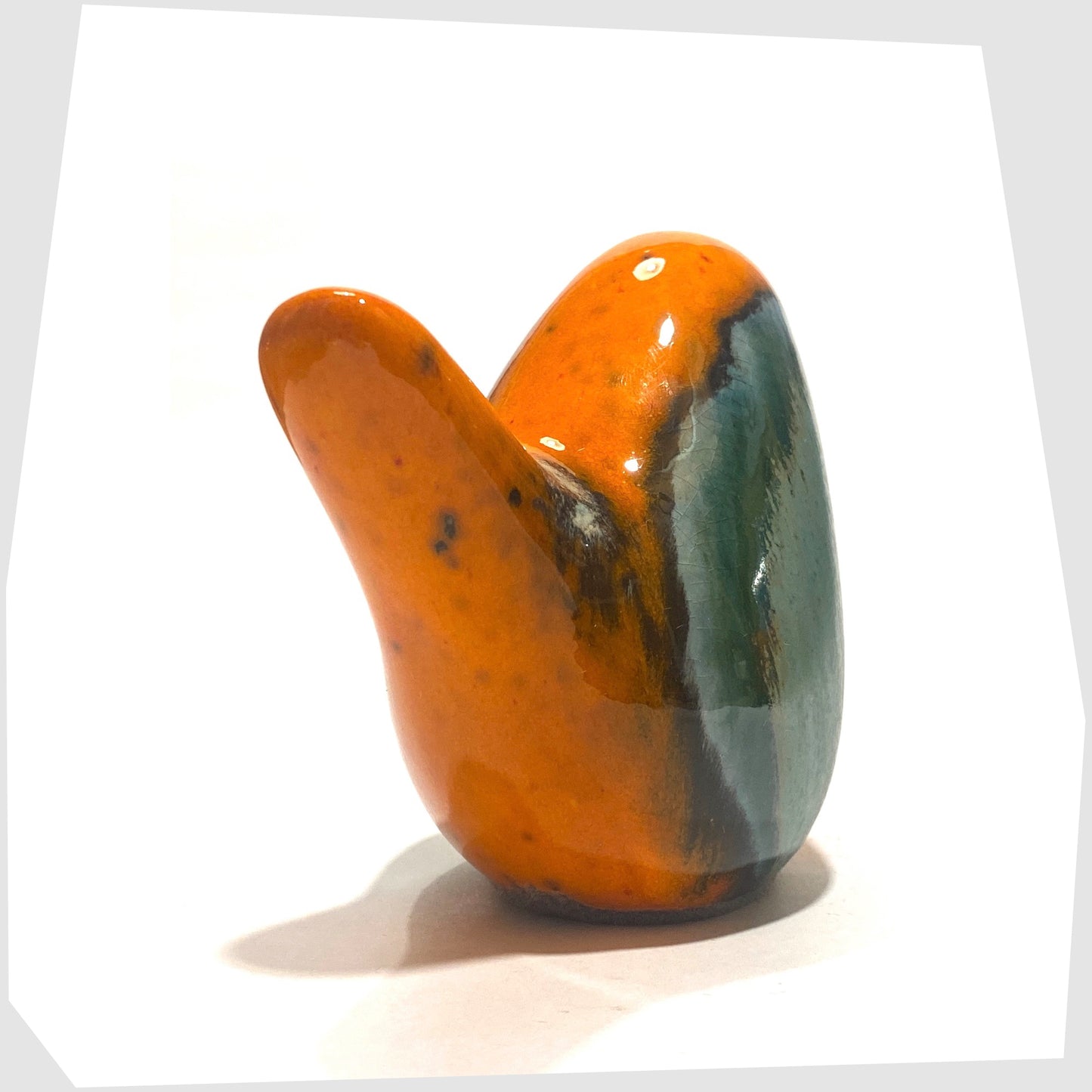 Rear angle of the Otto Keramik Ceramic Bird in Peru glaze of orange with sea green drip glaze, shown on a white background