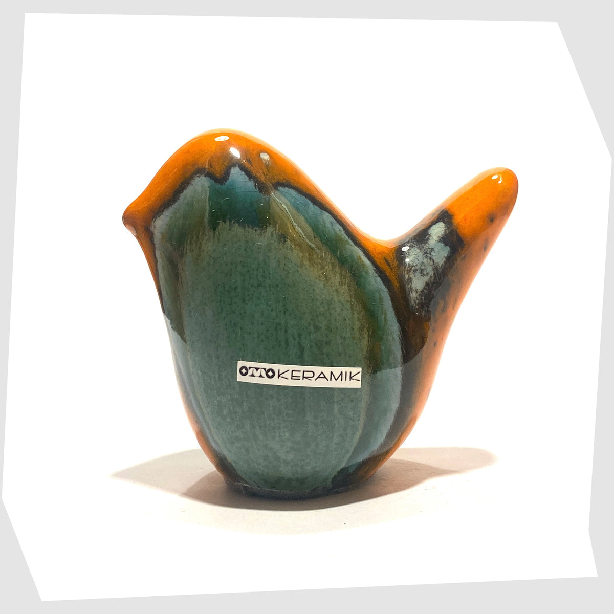 Otto Keramik Ceramic Bird in Peru glaze of orange with sea green drip glaze, shown on a white background