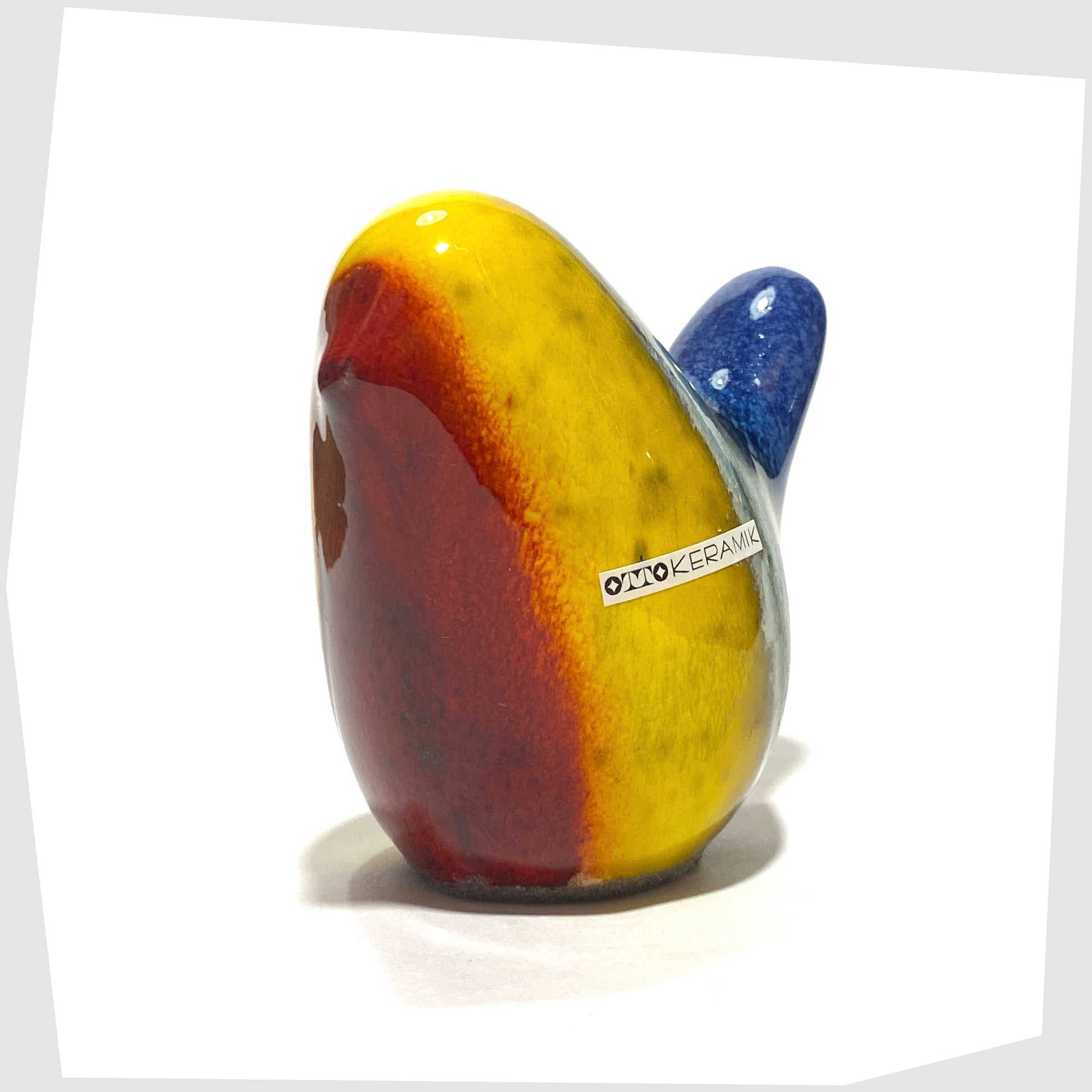 ceramic bird by otto keramik in multicoloured rainbow glaze of red, yellow, green and dark blue