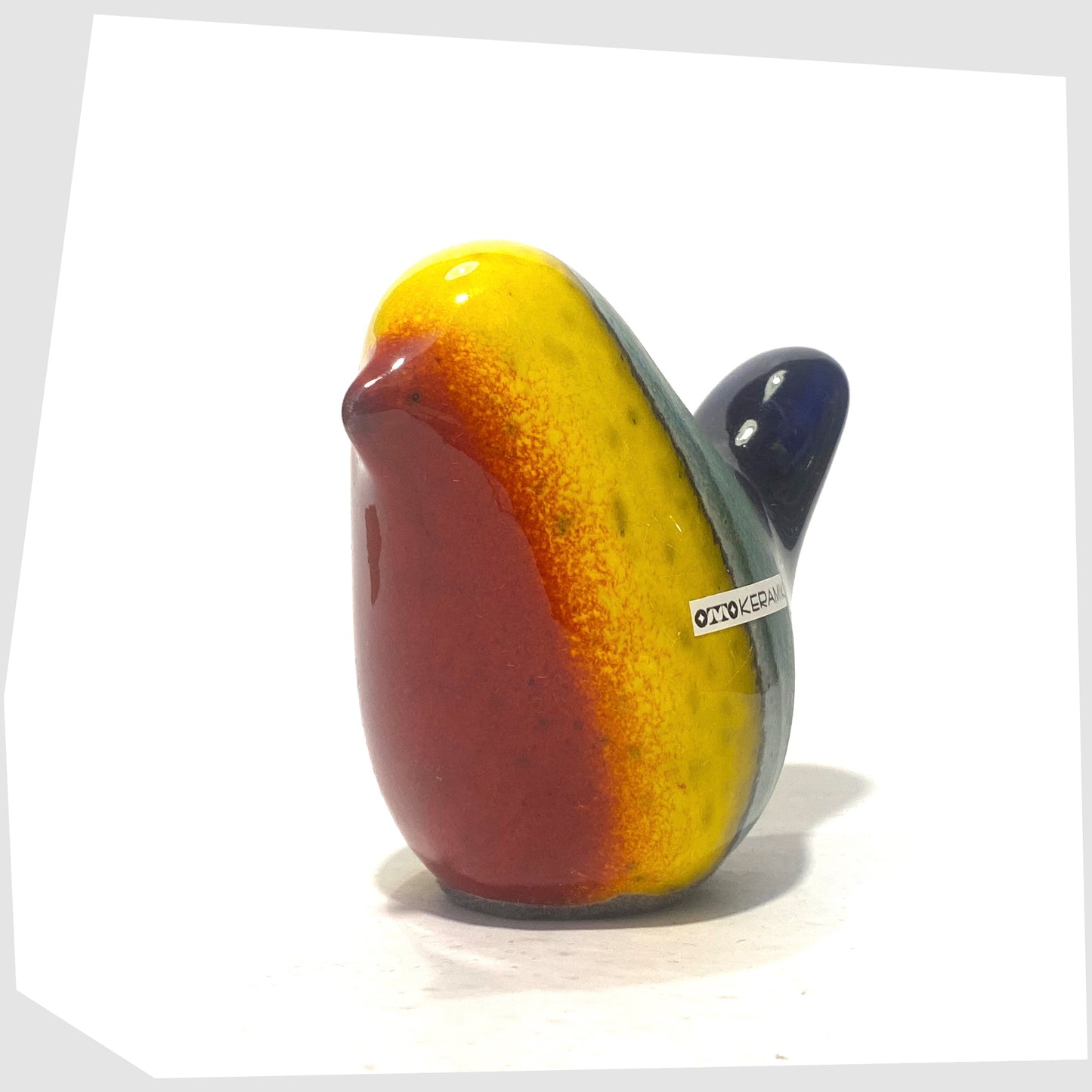 ceramic bird by otto keramik in multicoloured rainbow glaze of red, yellow, green and dark blue