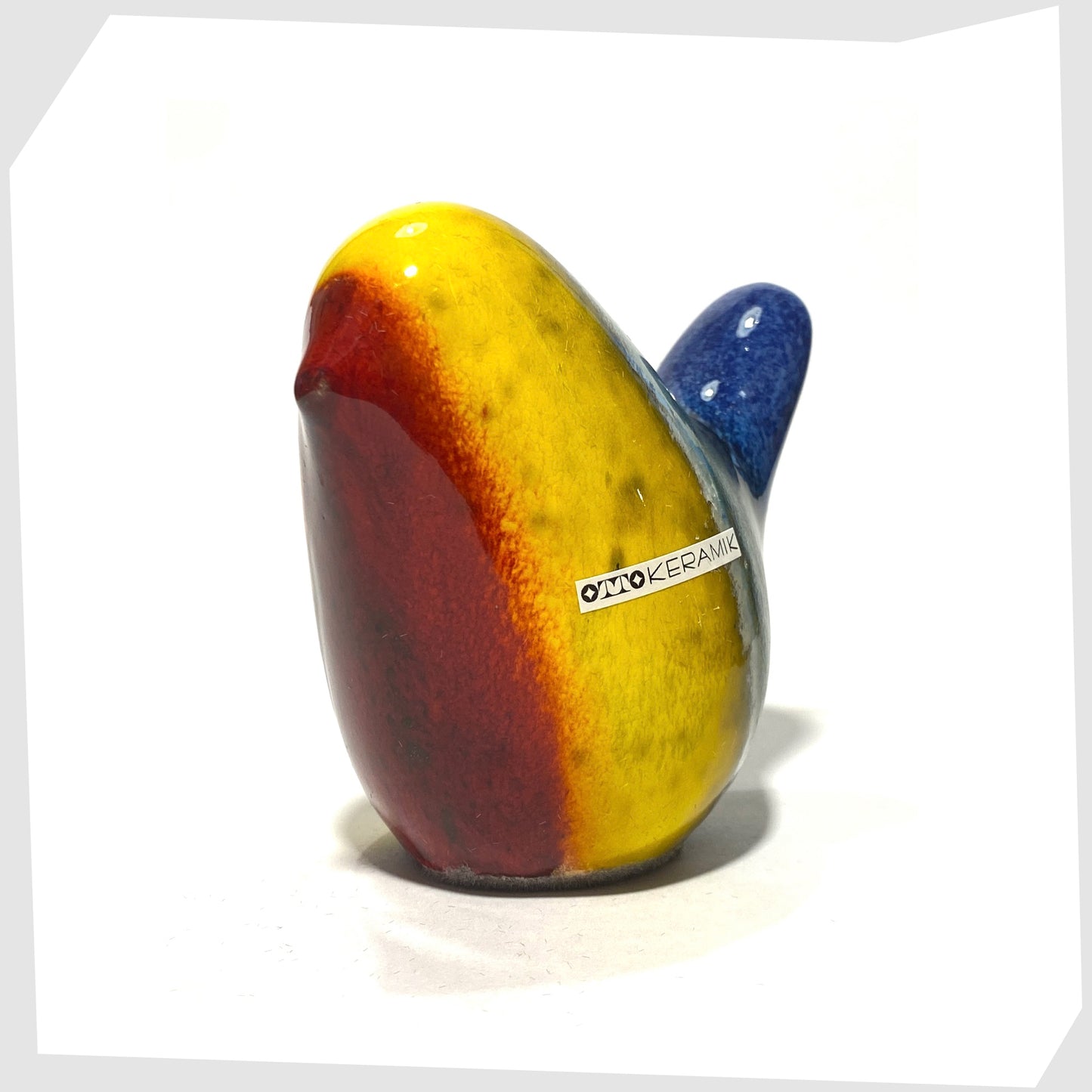 ceramic bird by otto keramik in multicoloured rainbow glaze of red, yellow, green and dark blue