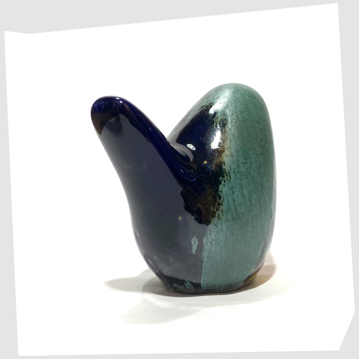 west german pottery-style ceramic bird in rainbow coloured glaze by otto keramik, tail angled view, shown on a white background