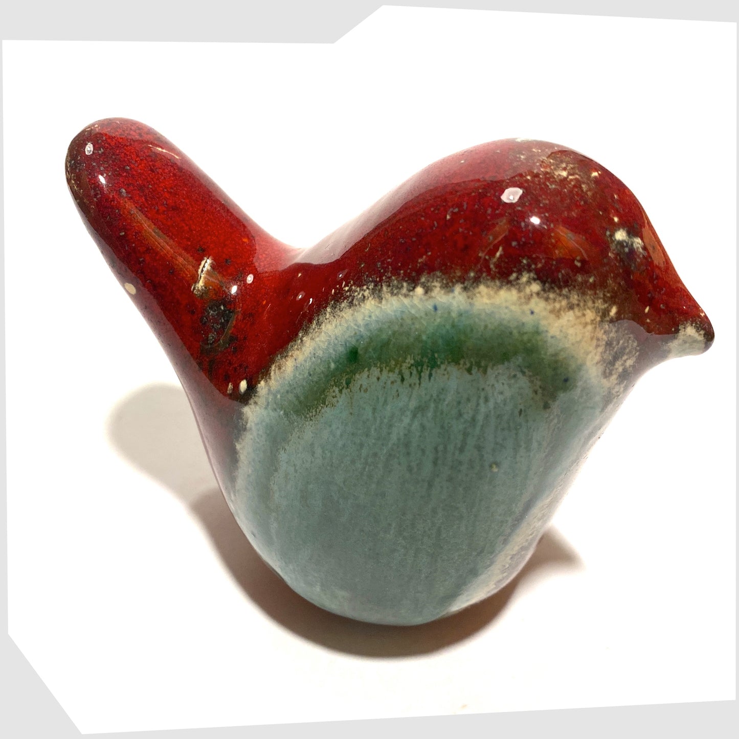 tail of the otto keramik ceramic bird in red and sea green Bolivia glaze