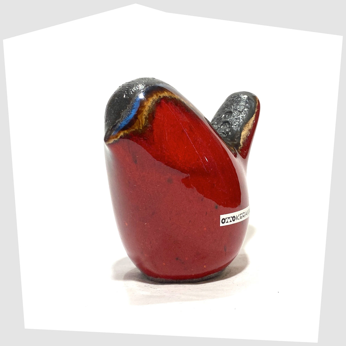 Front of the Otto Keramik ceramic bird in red glaze with grey fat lava along the spine, shown on a white background