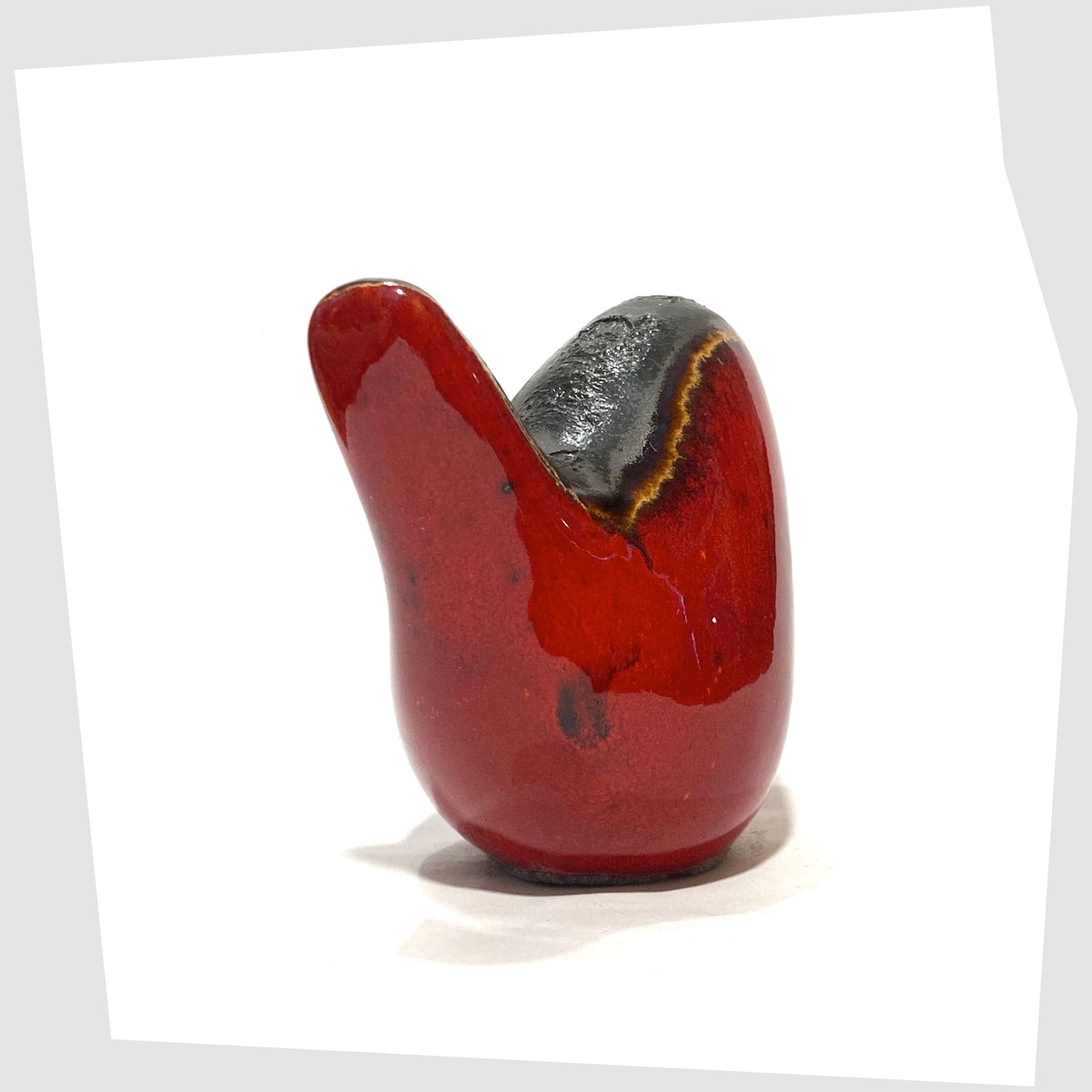 Rear of the Otto Keramik ceramic bird in red glaze with grey fat lava along the spine, shown on a white background