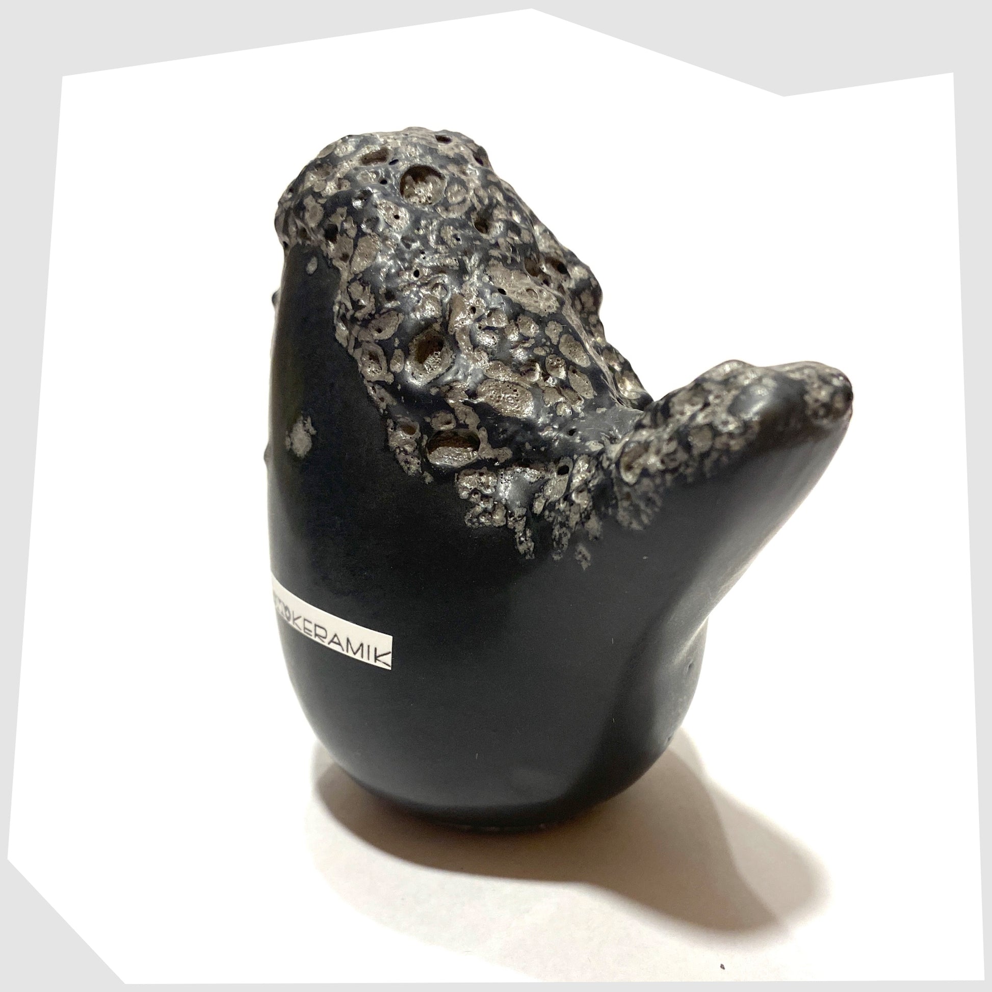 close up of the otto keramik ceramic bird in black glaze with deep fat lava