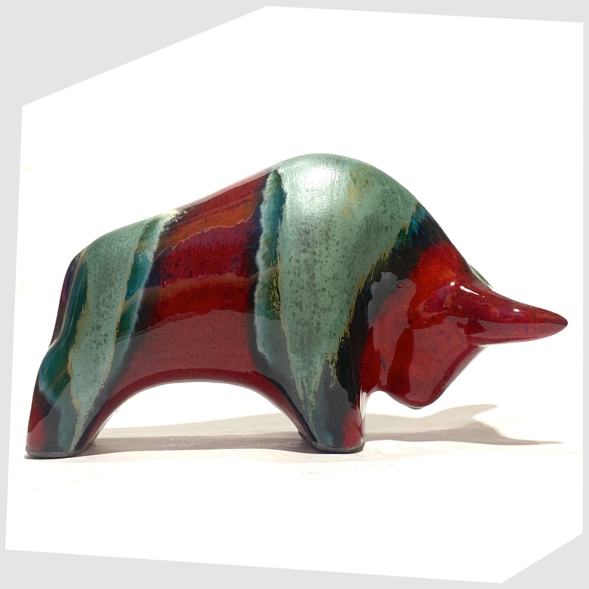 Otto Keramik Ceramic Bull figurine in Bolivia glaze of deep red with stripes of rich sea green, shown on a white background