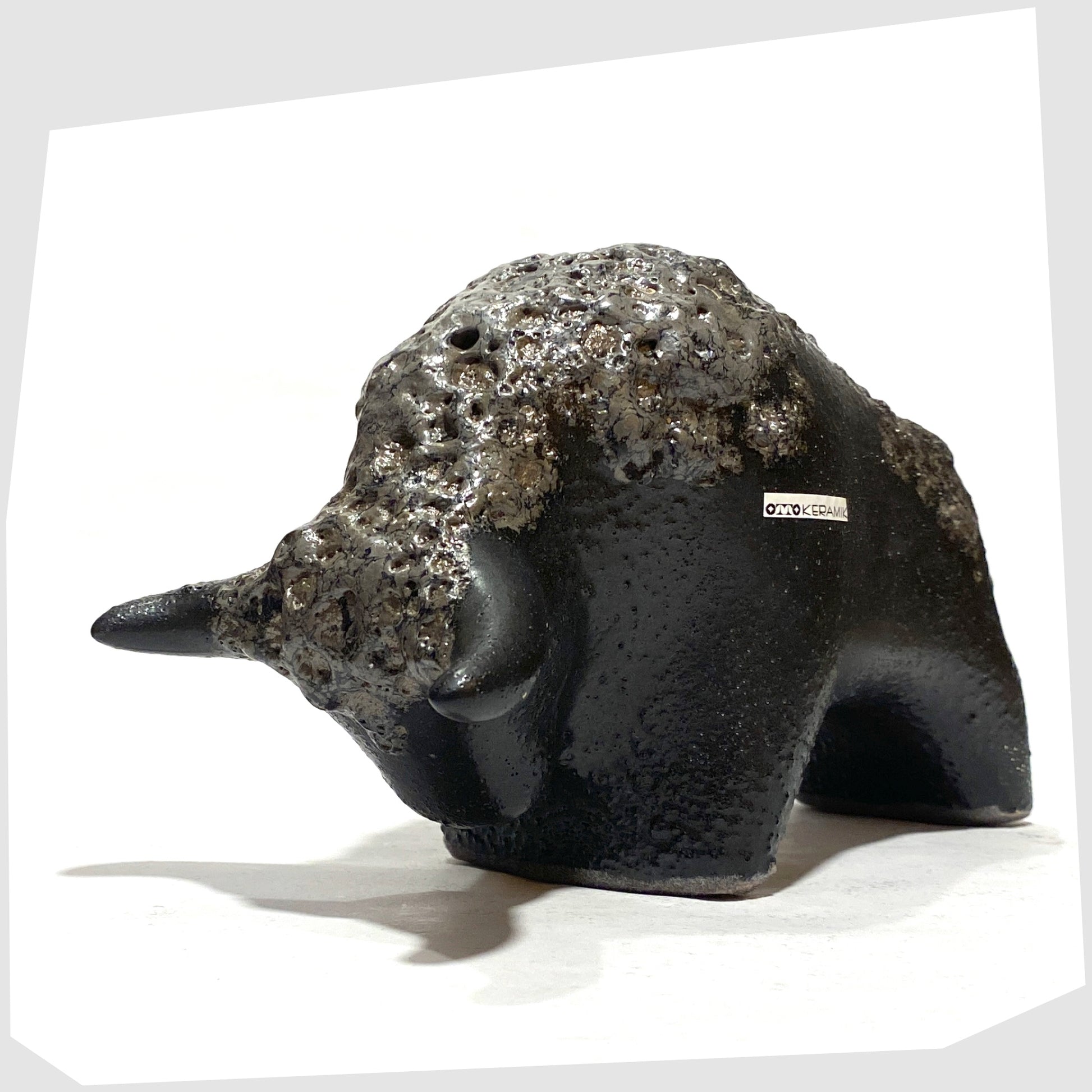 Front angle of the Otto Keramik Bull in textured black glaze with deep fat lava glazing along the spine, shown on a white background