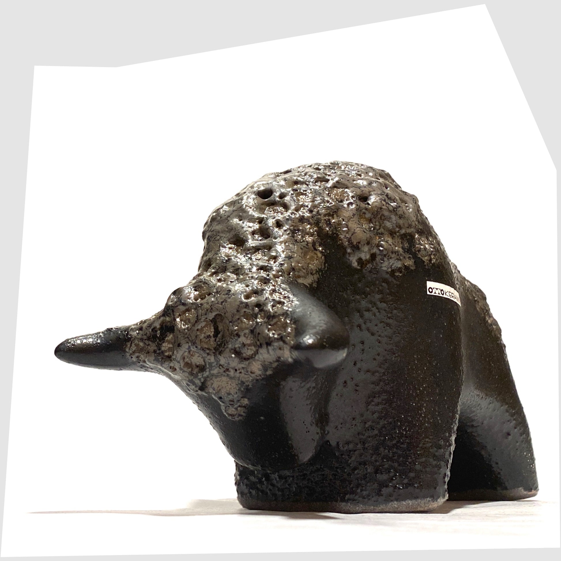 Front horns of the Otto Keramik Bull in textured black glaze with deep fat lava glazing along the spine, shown on a white background