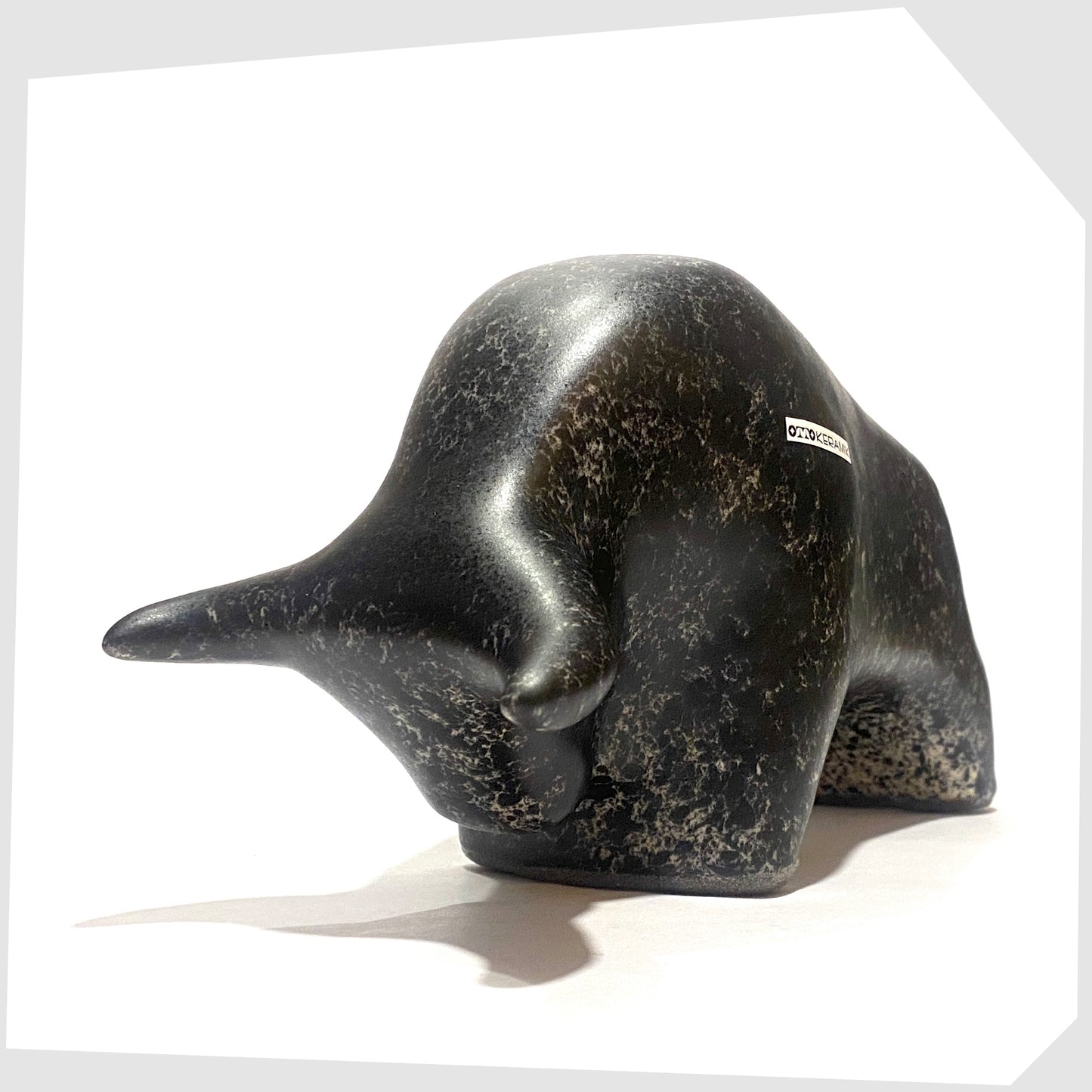 Front of the Otto Keramik ceramic bull-shaped figurine in black speckled glaze, shown on a white background