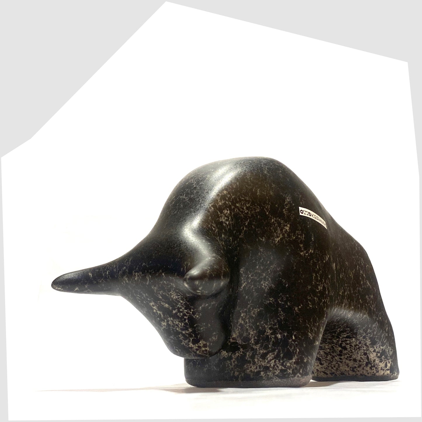 Front angle of the Otto Keramik ceramic bull-shaped figurine in black speckled glaze, shown on a white background