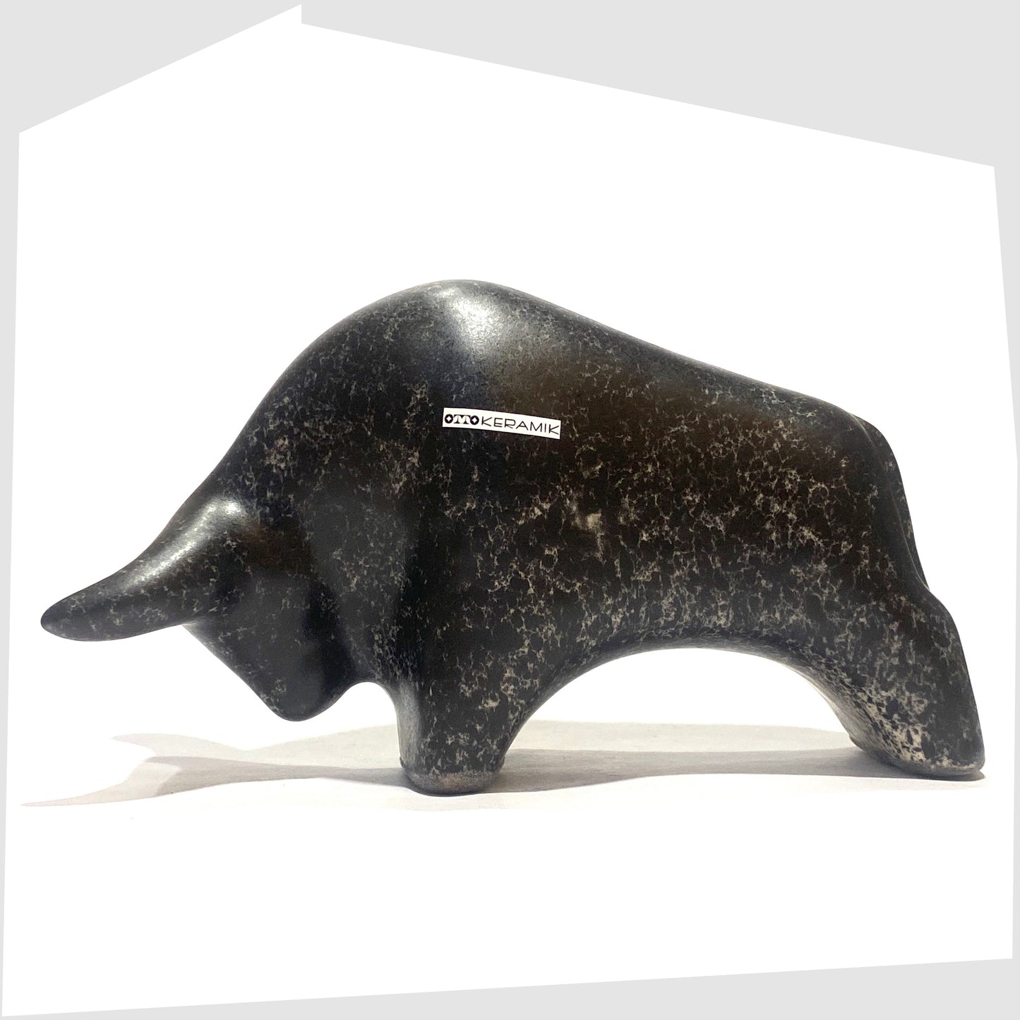 Otto Keramik ceramic bull-shaped figurine in black speckled glaze, shown on a white background
