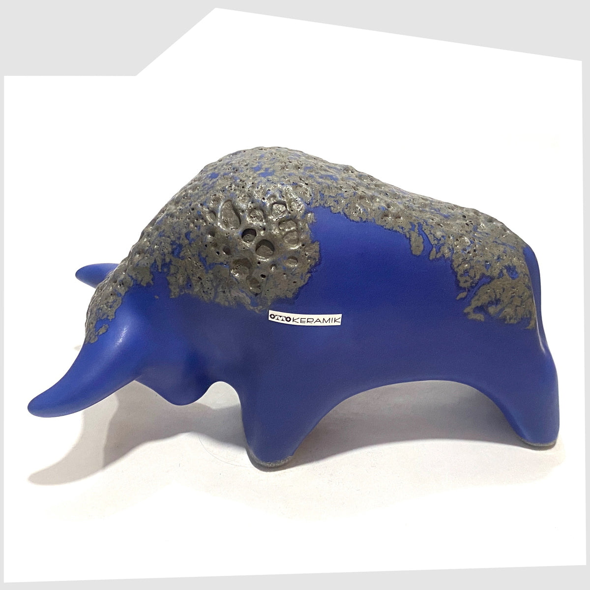 Overhead view of the Otto Keramik Bull-shaped ceramic ornament in blue with grey fat lava glaze, shown on a white background