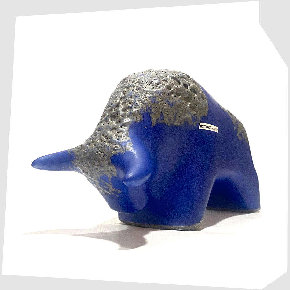 Front of the Otto Keramik Bull-shaped ceramic ornament in blue with grey fat lava glaze, shown on a white background
