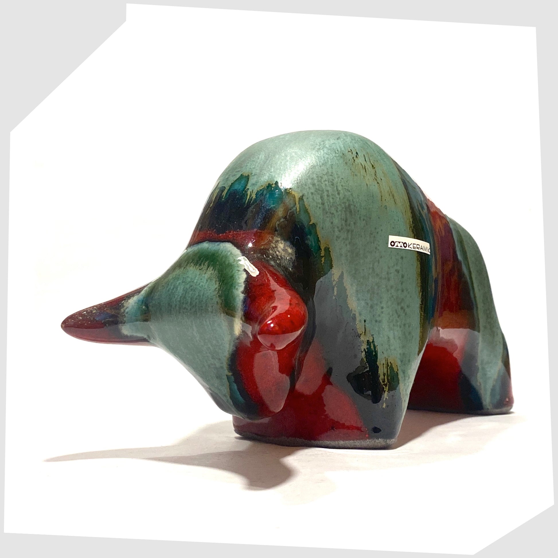Front of the Otto Keramik Bull in Bolivia glaze of deep red with stripes of rich sea green, shown on a white background