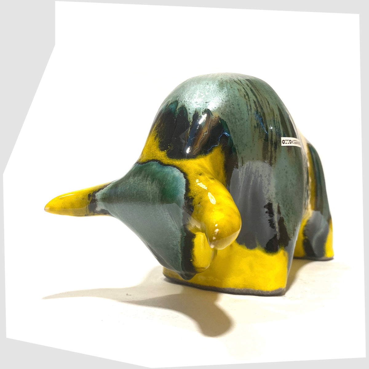 Front of the Otto Keramik Ceramic Bull in Brazil Glaze of yellow and sea green stripes, shown on a white background