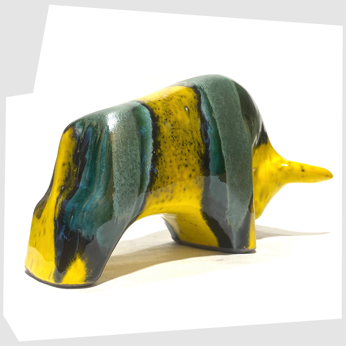 Rear of the Otto Keramik Ceramic Bull in Brazil Glaze of yellow and sea green stripes, shown on a white background
