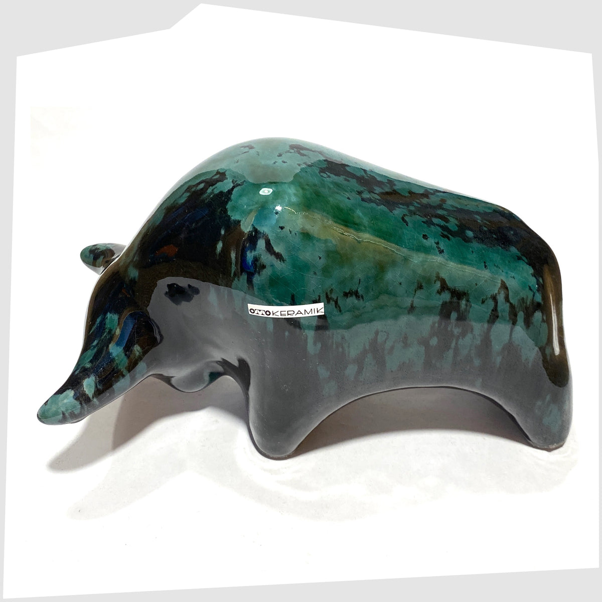 Overhead view of the Otto Keramik Bull in Ecuador glaze of gloss black and teal, shown on a white background