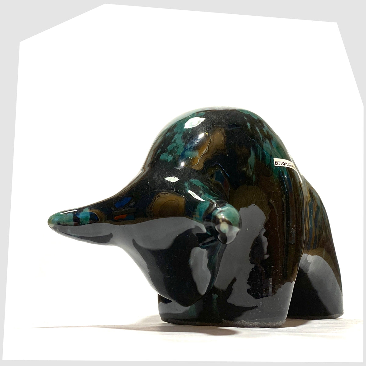 Front horns of the Otto Keramik Bull in Ecuador glaze of gloss black and teal, shown on a white background
