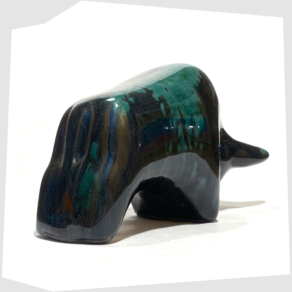 Rear of the Otto Keramik Bull in Ecuador glaze of gloss black and teal, shown on a white background