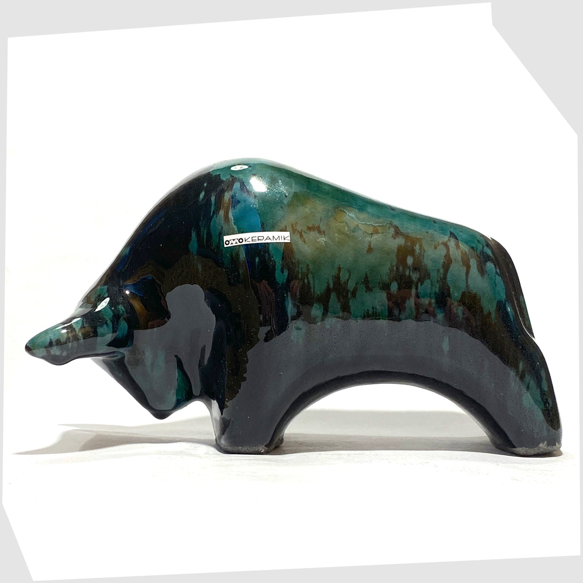 Otto Keramik Bull in Ecuador glaze of gloss black and teal, shown on a white background