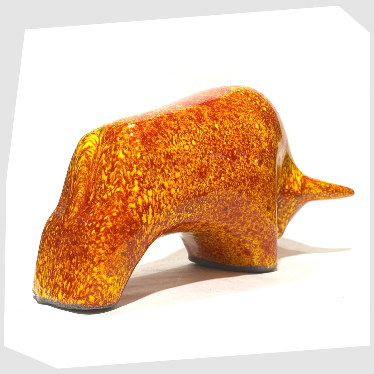 Rear of the Otto Keramik Bull in fire glaze of red, orange and yellow flecks, shown on a white background