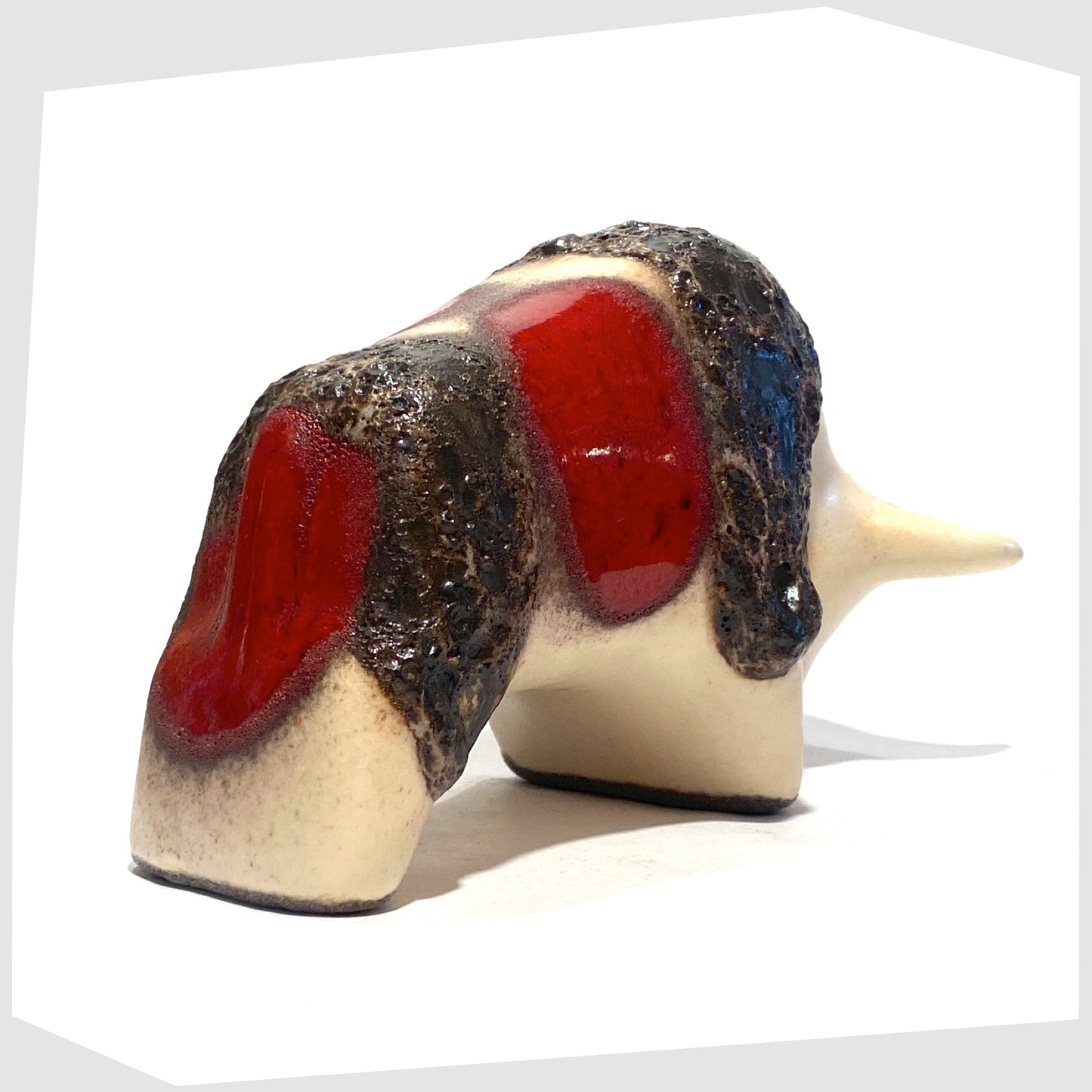 rear of the otto keramik ceramic bull shaped ornament in the red garnet glaze with stripes of deep fat lava