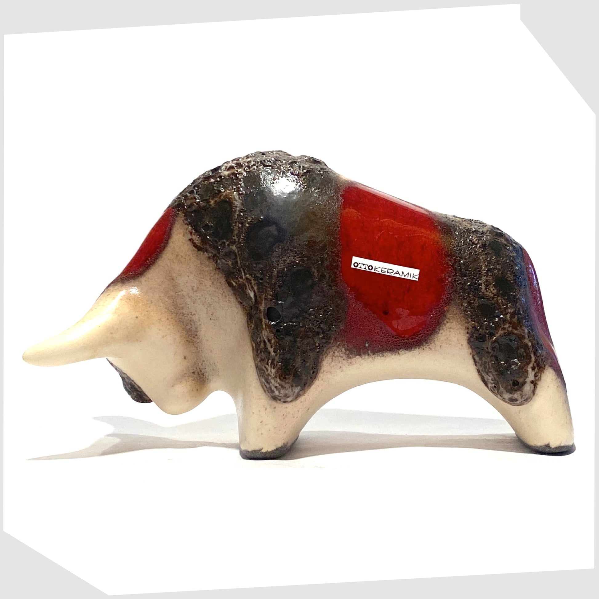otto keramik ceramic bull shaped ornament in the red garnet glaze with stripes of deep fat lava