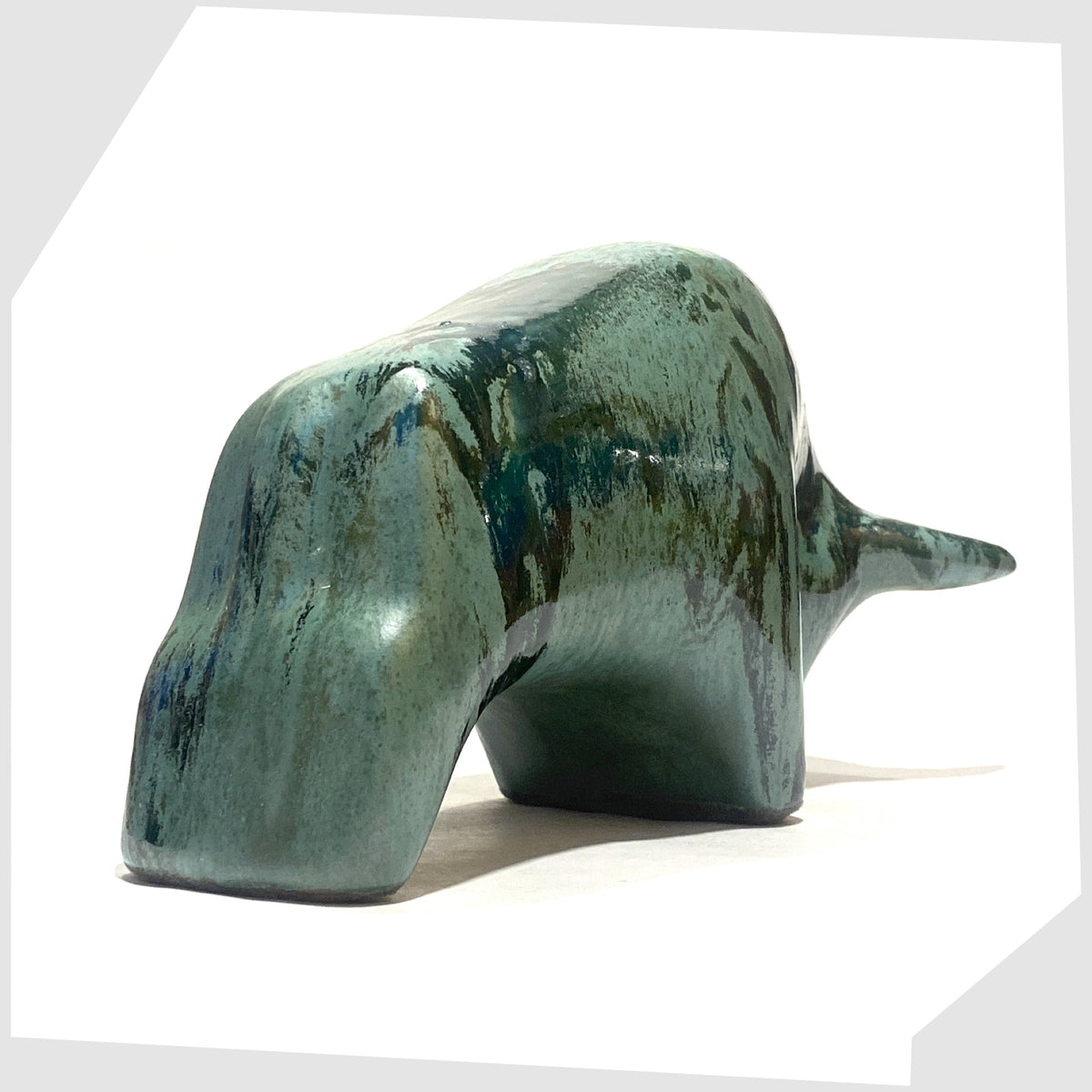 Rear of the Otto Keramik Bull shaped figurine in Malta glaze of rich sea green with darker drip glazing, shown on a white background