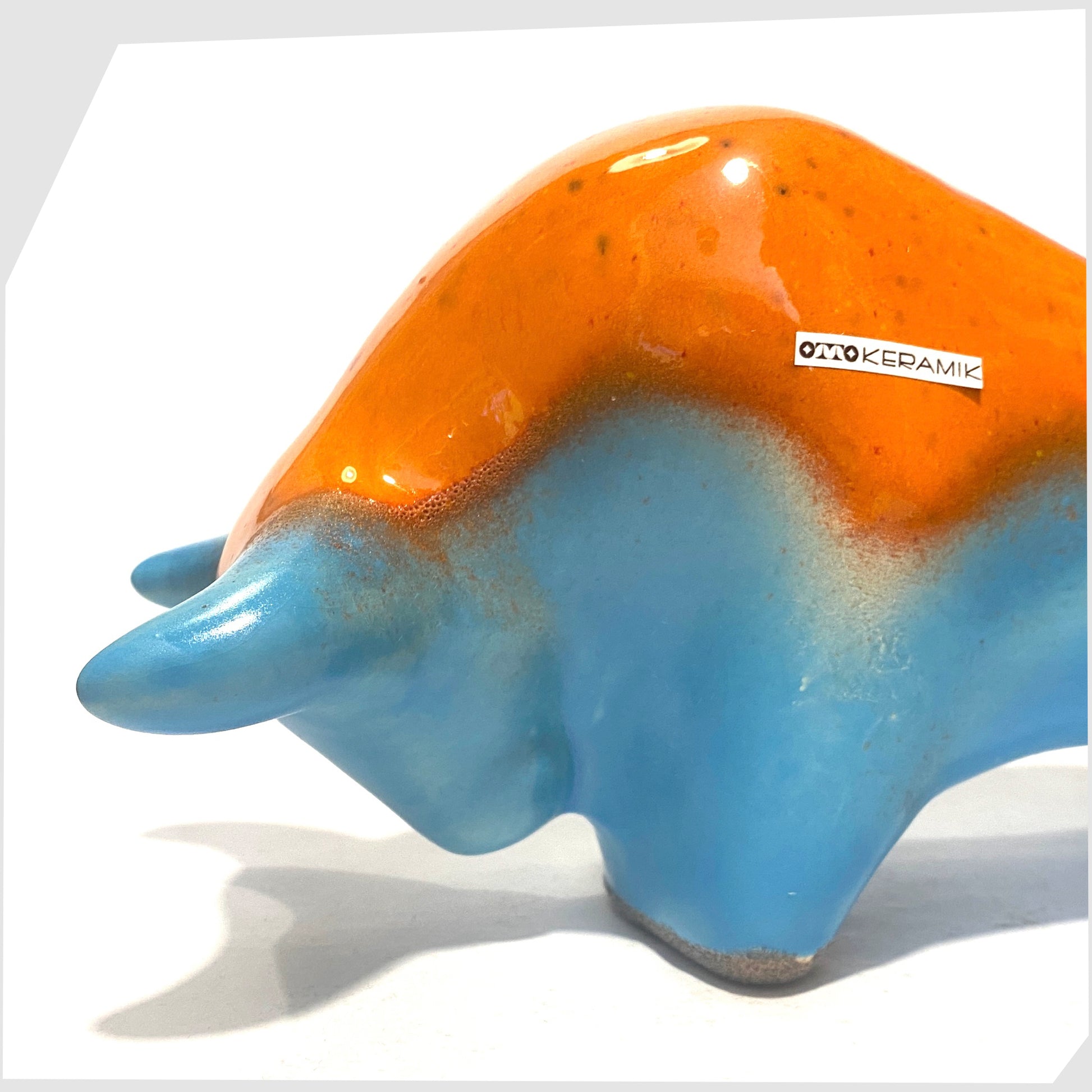 close up of the otto keramik bull in orange over blue glaze