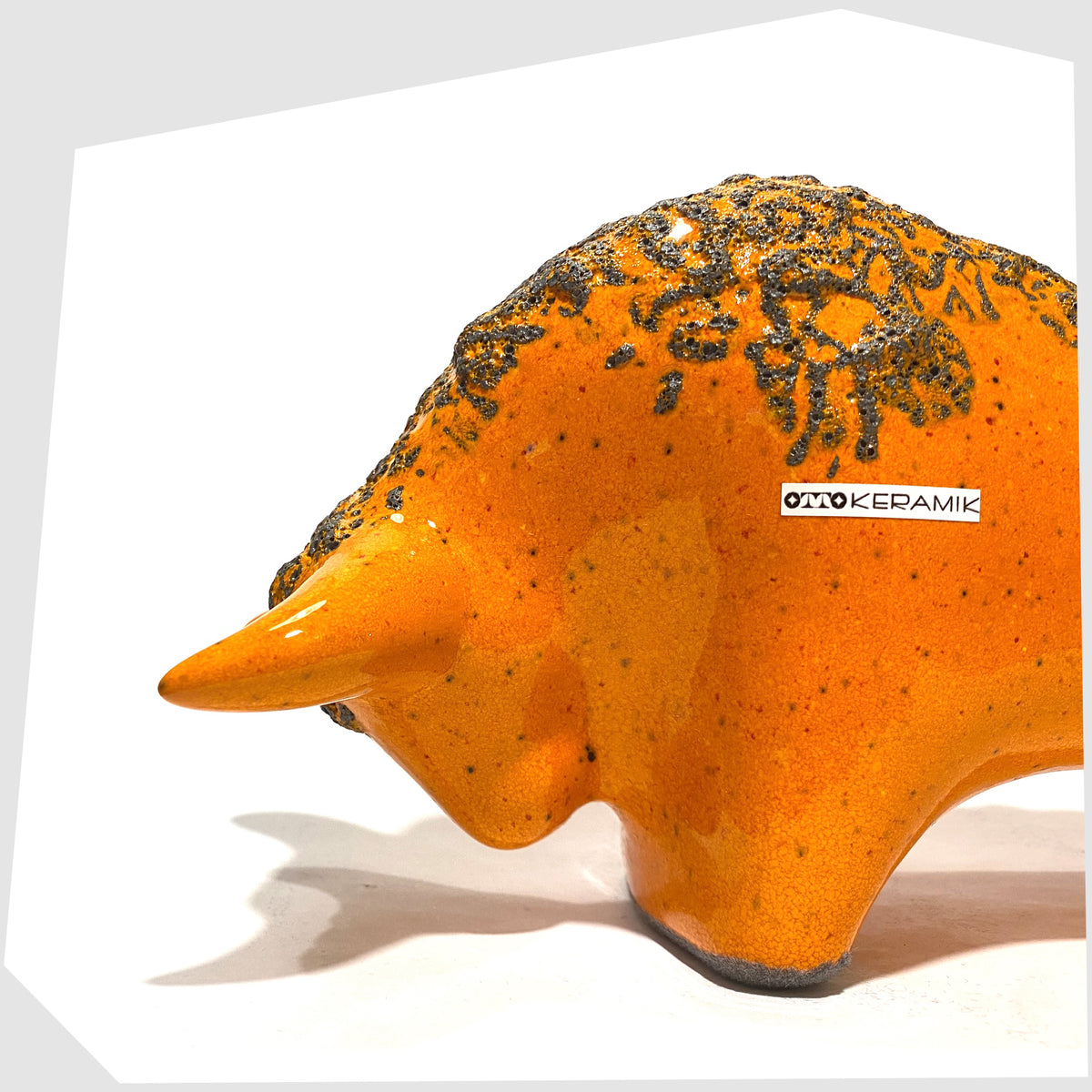 Close up of the Otto Keramik Bull in Orange Fat Lava Glaze, shown on a white background